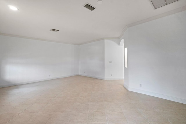 empty room featuring crown molding and light tile patterned flooring