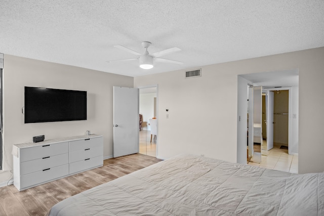 bedroom featuring a textured ceiling, light hardwood / wood-style flooring, and ceiling fan