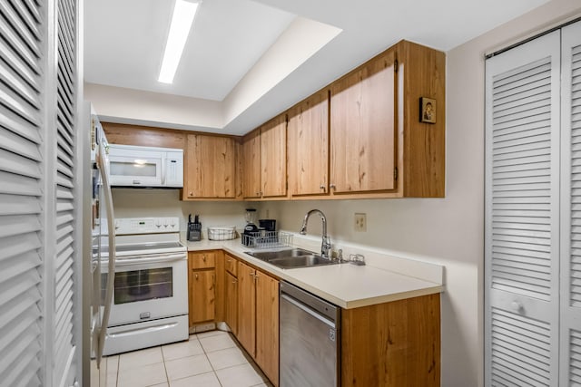 kitchen with light tile patterned flooring, white appliances, and sink