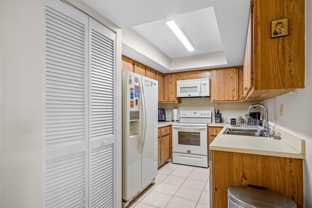 kitchen with light tile patterned flooring, white appliances, and sink