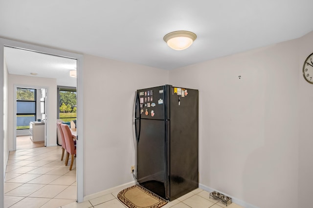 kitchen featuring black fridge and light tile patterned flooring