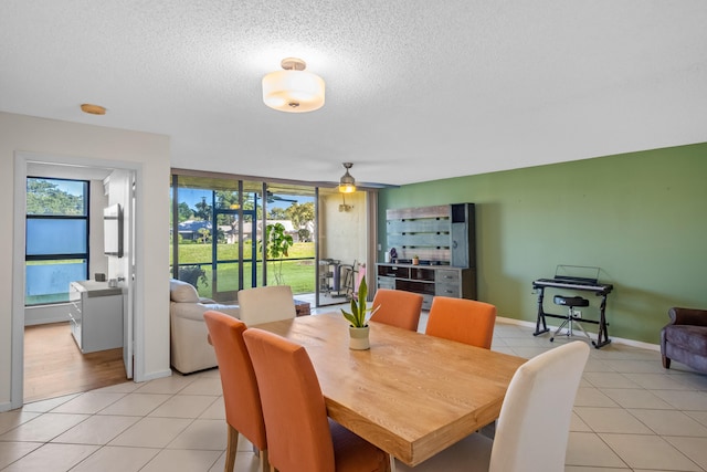 dining area featuring ceiling fan, light tile patterned floors, and a textured ceiling