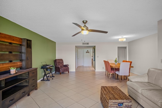 tiled living room featuring ceiling fan and a textured ceiling