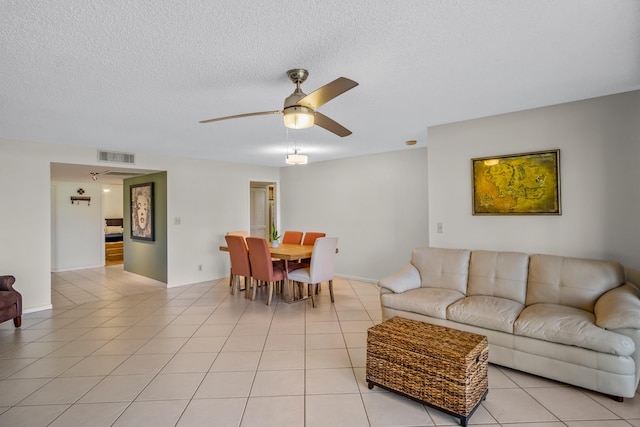 tiled living room featuring ceiling fan and a textured ceiling