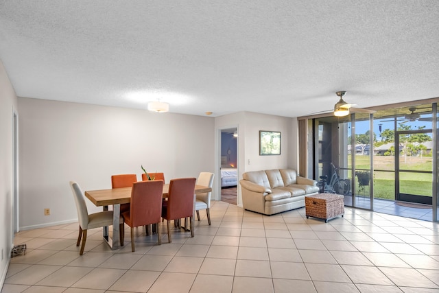 tiled dining room with a textured ceiling and ceiling fan