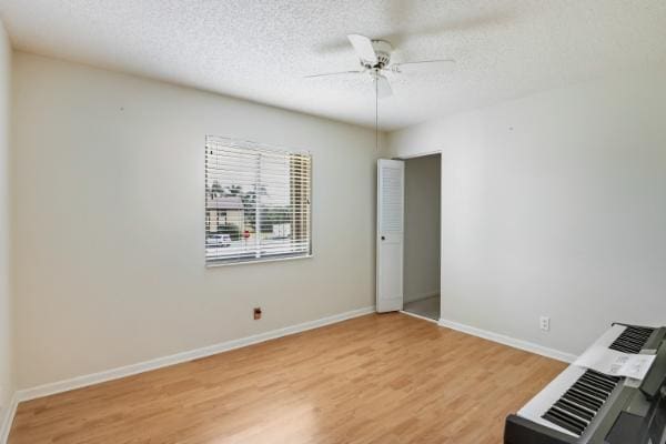 spare room with ceiling fan, wood-type flooring, and a textured ceiling