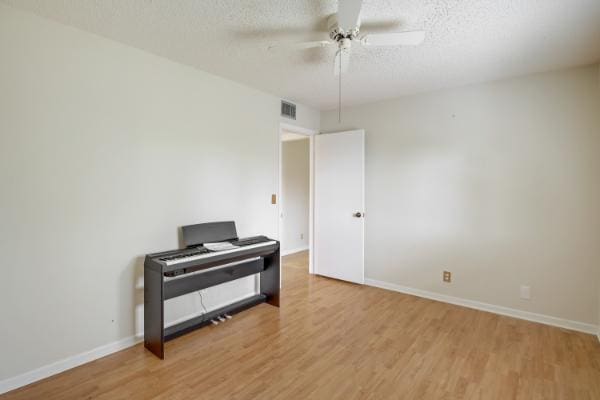 433 Pine Glen Ln Unit A2, Greenacres, FL 33463 - unfurnished room with a ceiling fan, wood finished floors, and a textured ceiling