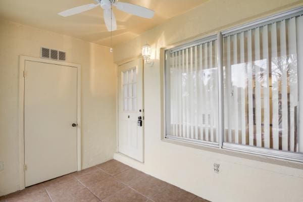 interior space with ceiling fan and light tile patterned flooring