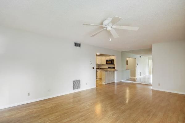 433 Pine Glen Ln Unit A2, Greenacres, FL 33463 - unfurnished living room featuring a ceiling fan and light wood-type flooring