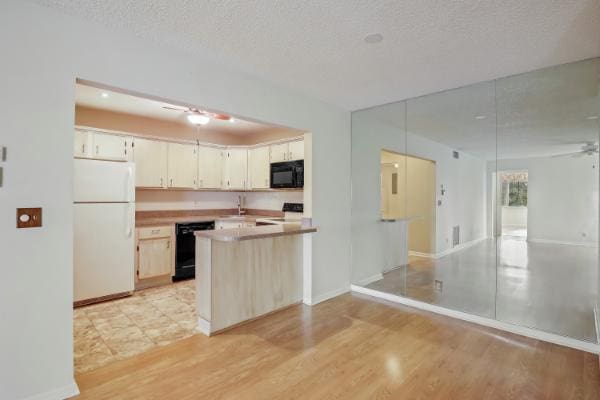 433 Pine Glen Ln Unit A2, Greenacres, FL 33463 - kitchen with black appliances, ceiling fan, a peninsula, a textured ceiling, and light wood-style floors