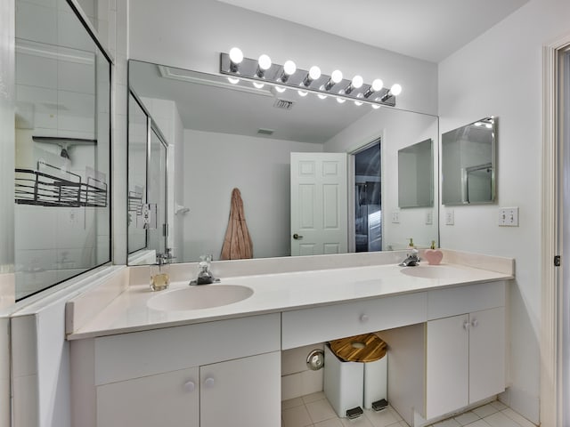 bathroom with vanity, tile patterned floors, and a shower with door