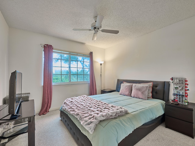 carpeted bedroom featuring a textured ceiling and ceiling fan