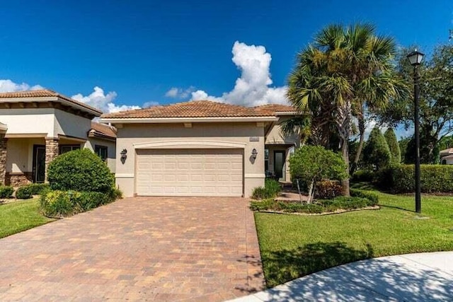 mediterranean / spanish-style home with a garage and a front lawn