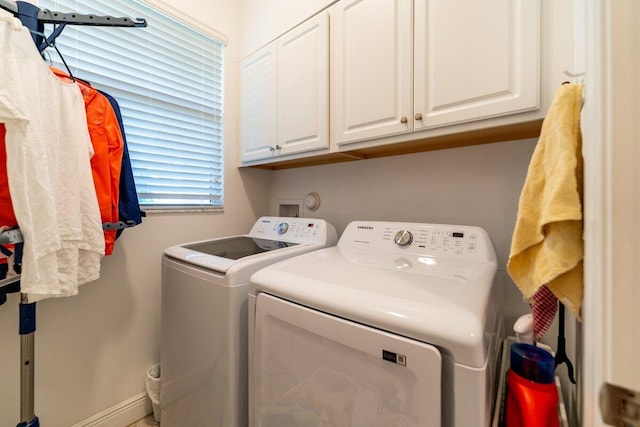 laundry room featuring washer and clothes dryer and cabinets