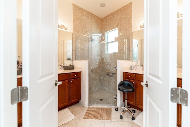 bathroom with tile patterned floors, a shower with door, and vanity