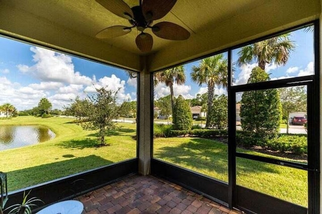 unfurnished sunroom with ceiling fan and a water view