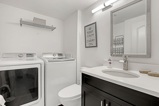 bathroom with vanity, separate washer and dryer, and toilet