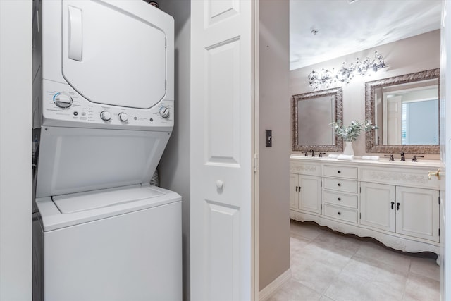 clothes washing area featuring a sink, laundry area, light tile patterned floors, and stacked washer / drying machine