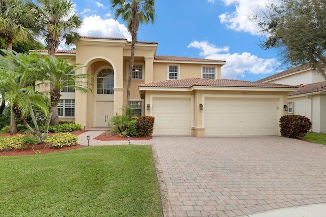 mediterranean / spanish-style house featuring a front yard and a garage