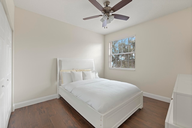 bedroom with dark hardwood / wood-style floors, ceiling fan, and a closet