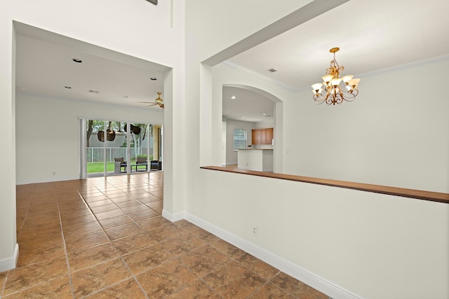 hall with crown molding, baseboards, and an inviting chandelier