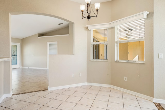 spare room featuring light tile patterned floors, vaulted ceiling, and a notable chandelier