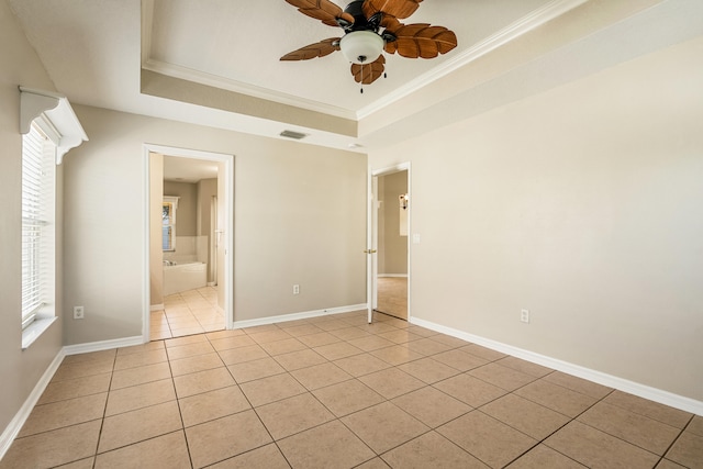 tiled spare room with a tray ceiling, ceiling fan, and ornamental molding