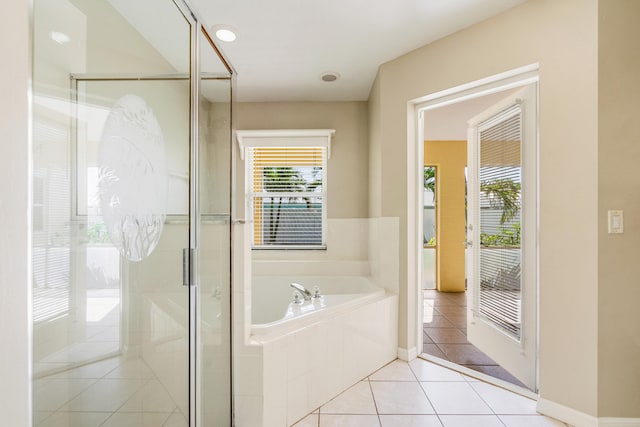 bathroom featuring tile patterned flooring, separate shower and tub, and a wealth of natural light