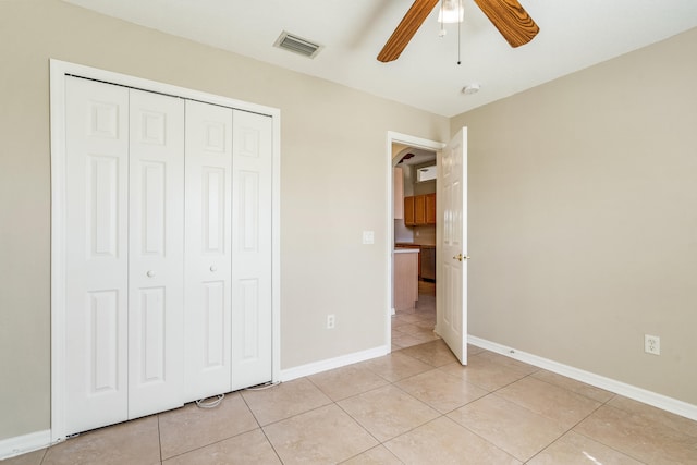 unfurnished bedroom with ceiling fan, light tile patterned flooring, and a closet