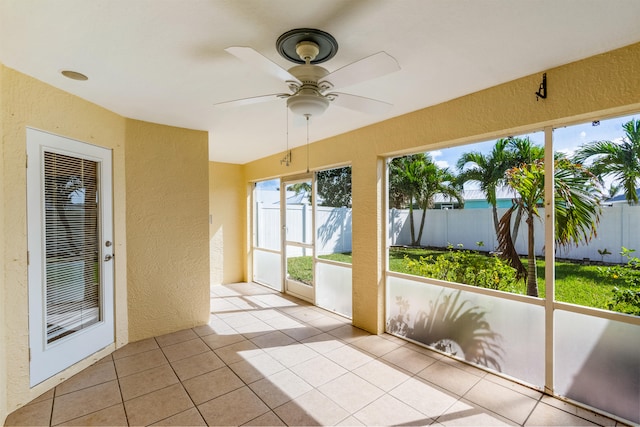 unfurnished sunroom with ceiling fan