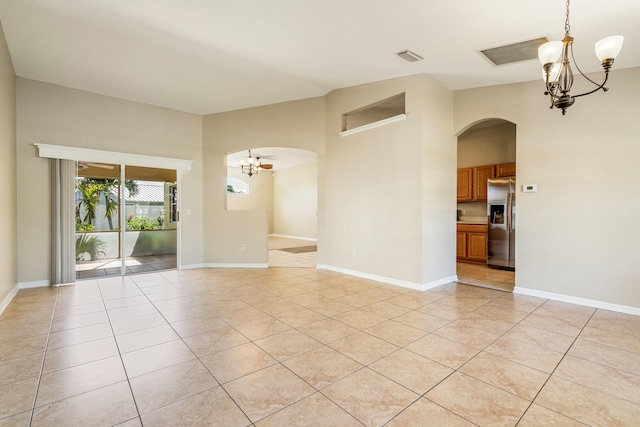 tiled empty room with an inviting chandelier