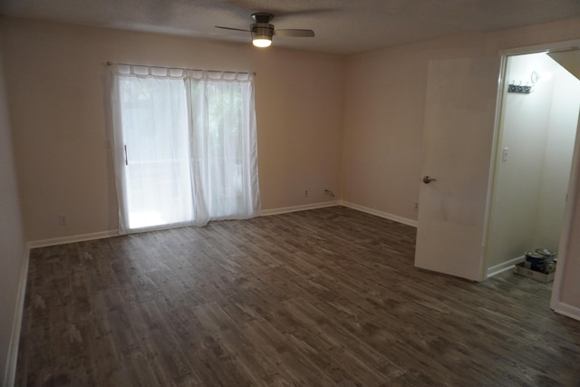 empty room with dark hardwood / wood-style flooring and ceiling fan