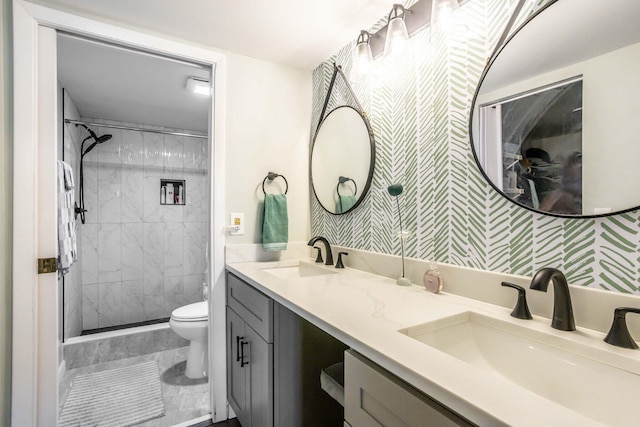 bathroom featuring vanity, toilet, and tiled shower