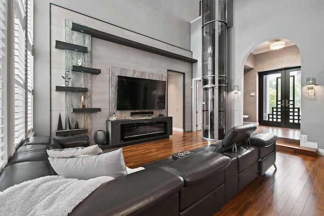 living room with french doors, dark hardwood / wood-style floors, and a high ceiling