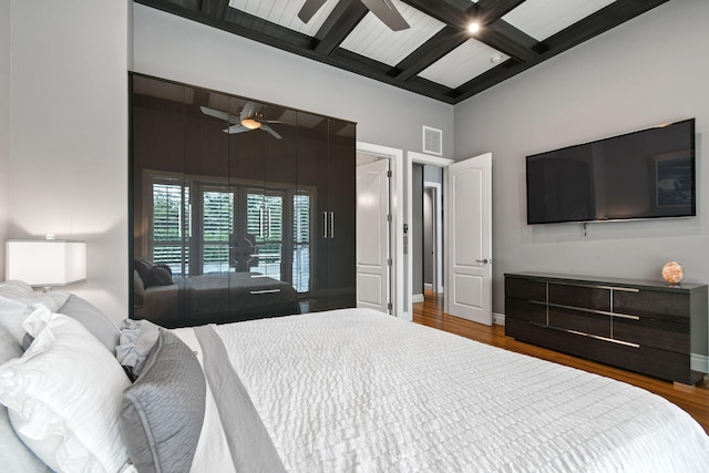 bedroom featuring beamed ceiling, dark hardwood / wood-style floors, ceiling fan, and coffered ceiling