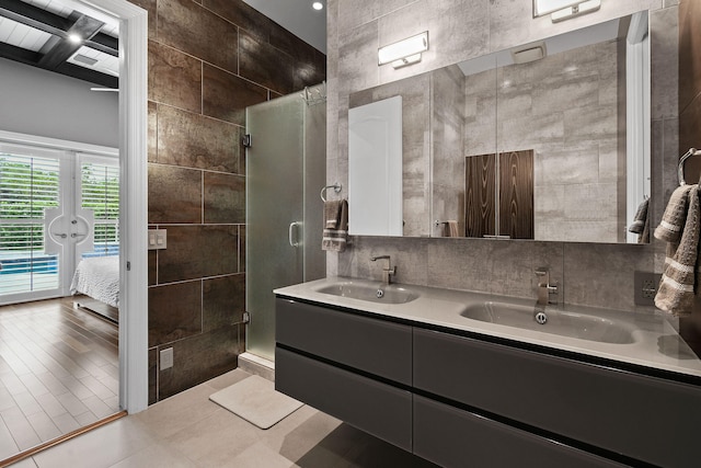 bathroom with vanity, a shower with door, tile walls, and hardwood / wood-style flooring