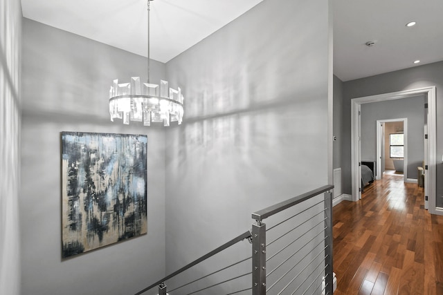 hall with an inviting chandelier and dark wood-type flooring