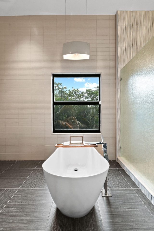 bathroom featuring tile patterned flooring, tile walls, and a tub