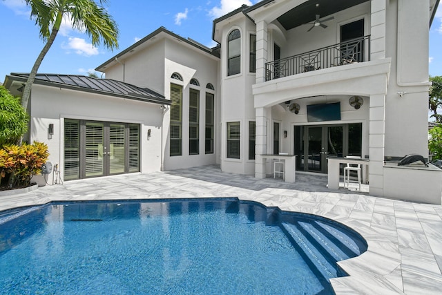 back of house featuring a balcony, ceiling fan, a patio area, and exterior kitchen