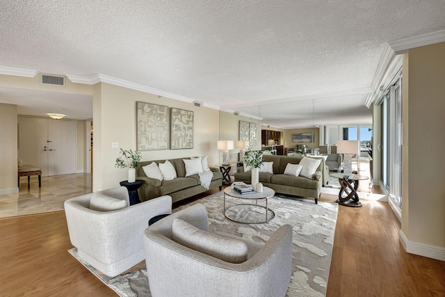 living room featuring hardwood / wood-style flooring, crown molding, and a textured ceiling