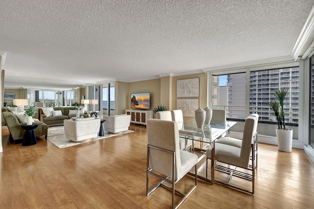 dining area with crown molding, light hardwood / wood-style floors, and a textured ceiling