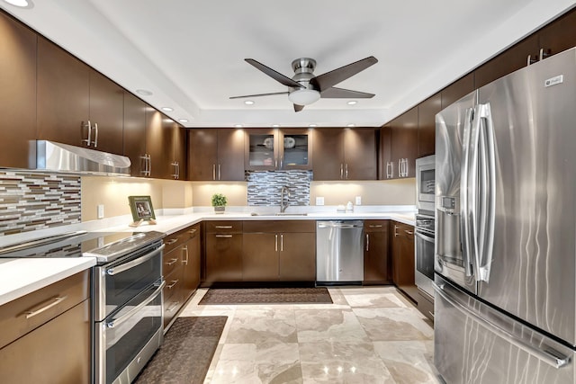 kitchen featuring appliances with stainless steel finishes, backsplash, dark brown cabinetry, ceiling fan, and sink