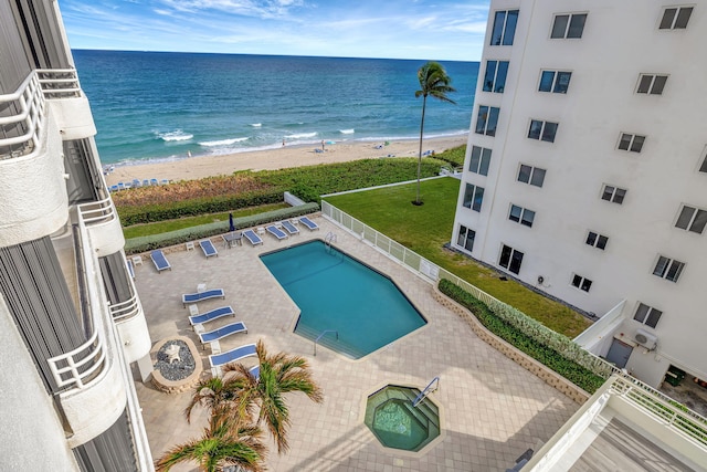 view of swimming pool with a water view, a patio, and a beach view