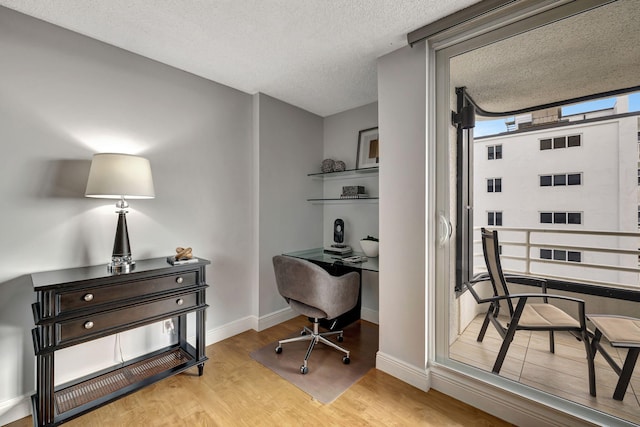 office with a textured ceiling and light hardwood / wood-style flooring