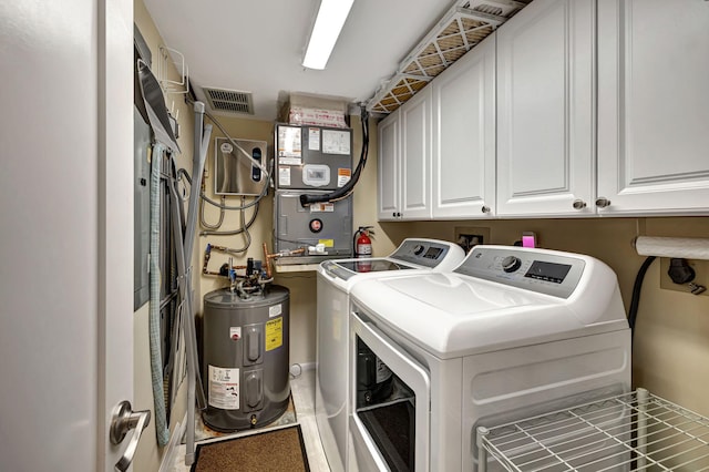 clothes washing area with separate washer and dryer, water heater, and cabinets