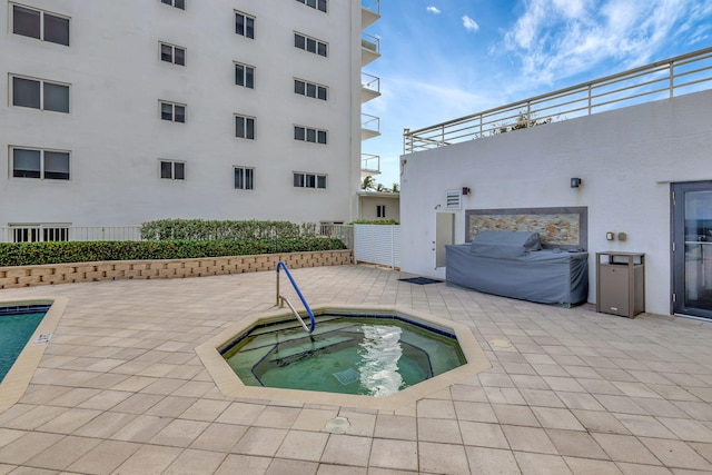 view of pool with a community hot tub and a patio area