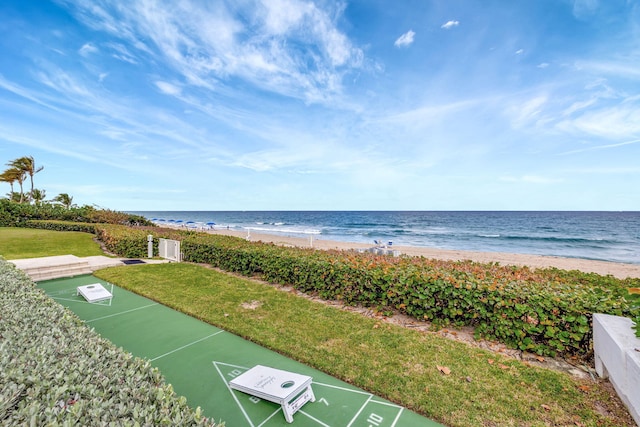 view of community with a view of the beach, a water view, and a lawn