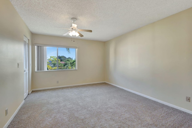 carpeted empty room with ceiling fan and a textured ceiling