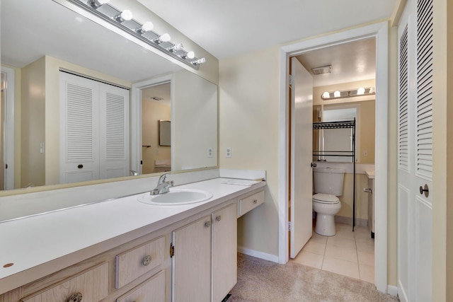 bathroom with tile patterned flooring, vanity, and toilet