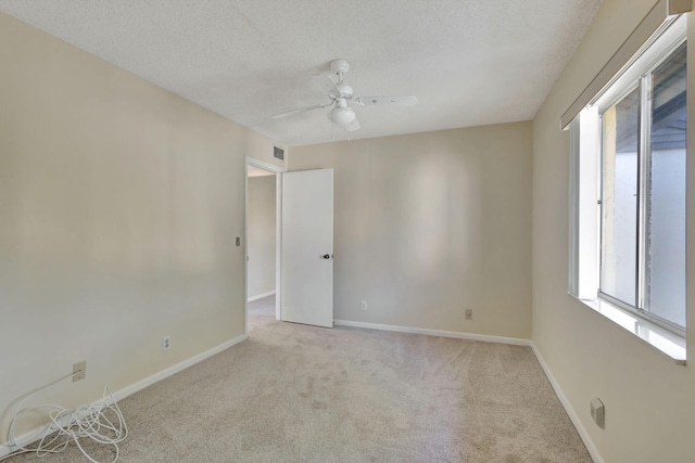 carpeted empty room featuring a textured ceiling and ceiling fan